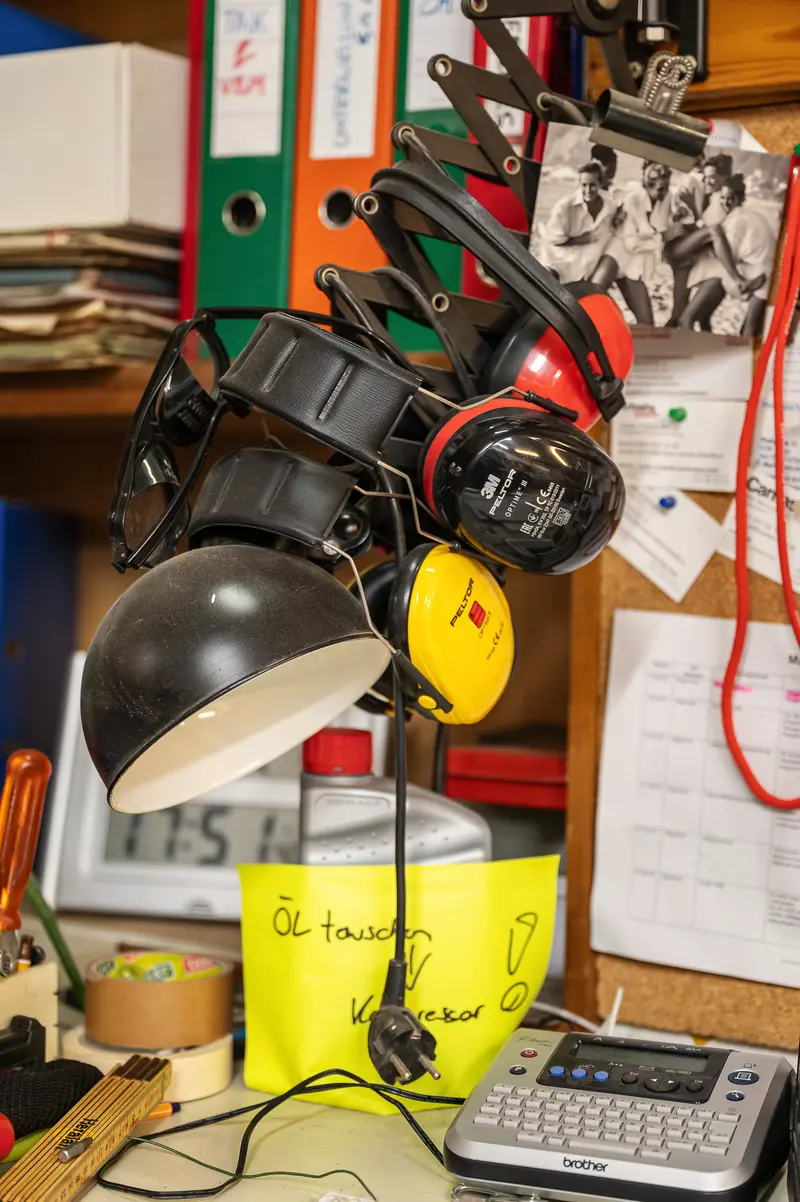 Cluttered Desk with Camera, Headphones, and Office Supplies