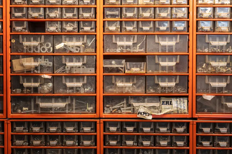 Orange Storage Cabinet with Transparent Drawers Filled with Mechanical Parts