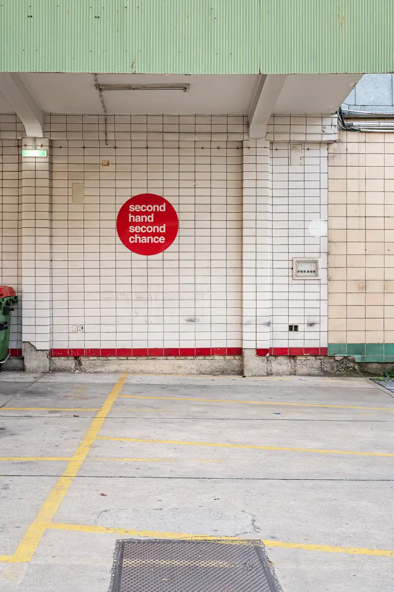 Second Hand Second Chance Storefront with Red Sign in Urban Parking Area