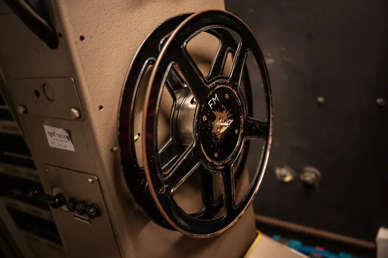 Vintage Film Reel on Analog Projector Machine in Low Light