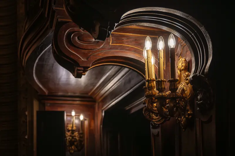 Ornate Candelabra Illuminating Elegant Wooden Interior with Antique Candle Sconce