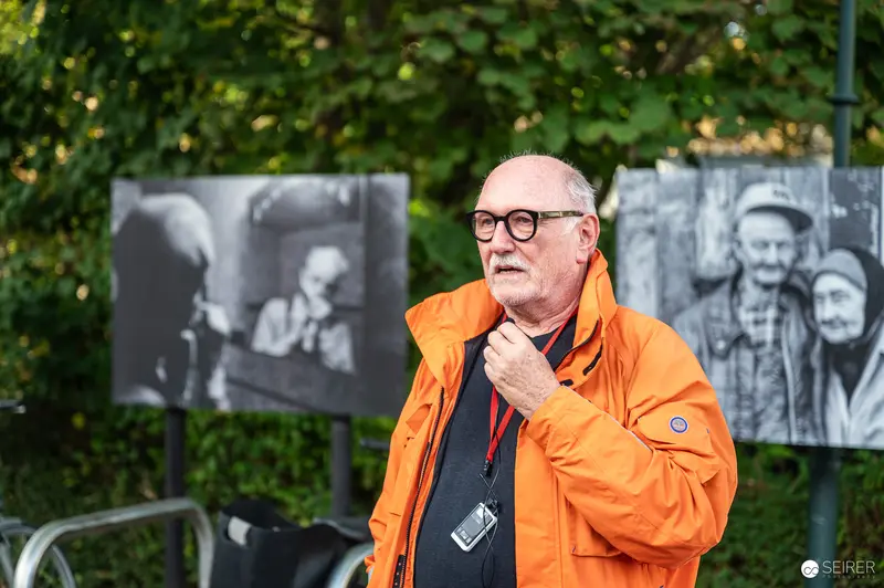 Lois Lammerhuber Presenting La Gacilly Baden Photography Tour in Orange Jacket