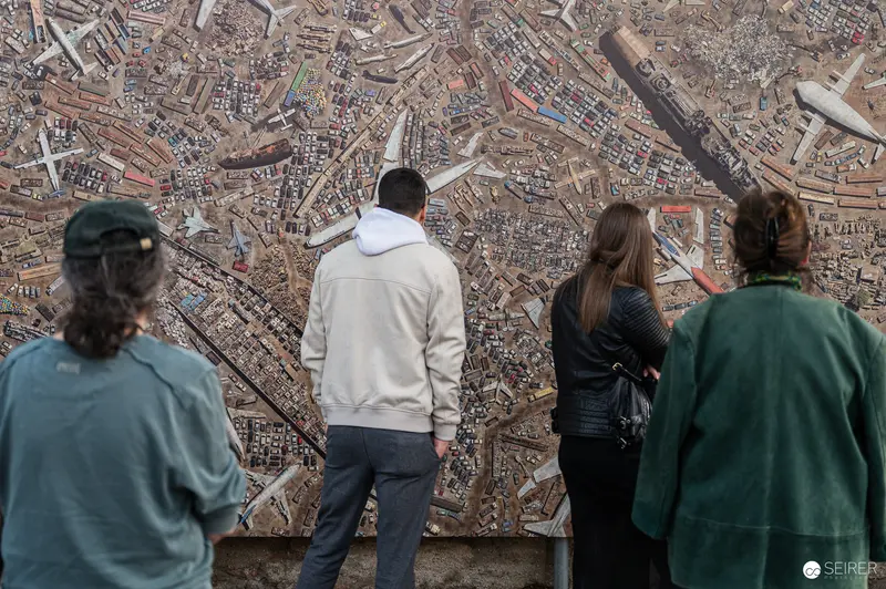 Visitors Examining Detailed Urban Aerial Map at Exhibition