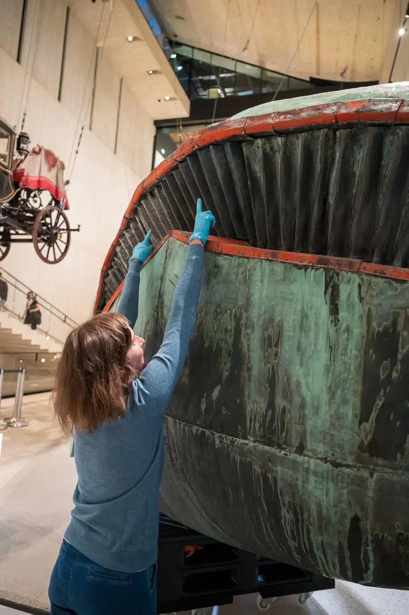 Conservator Examining Poldi Whale Sculpture at Wien Museum Restoration Demonstration