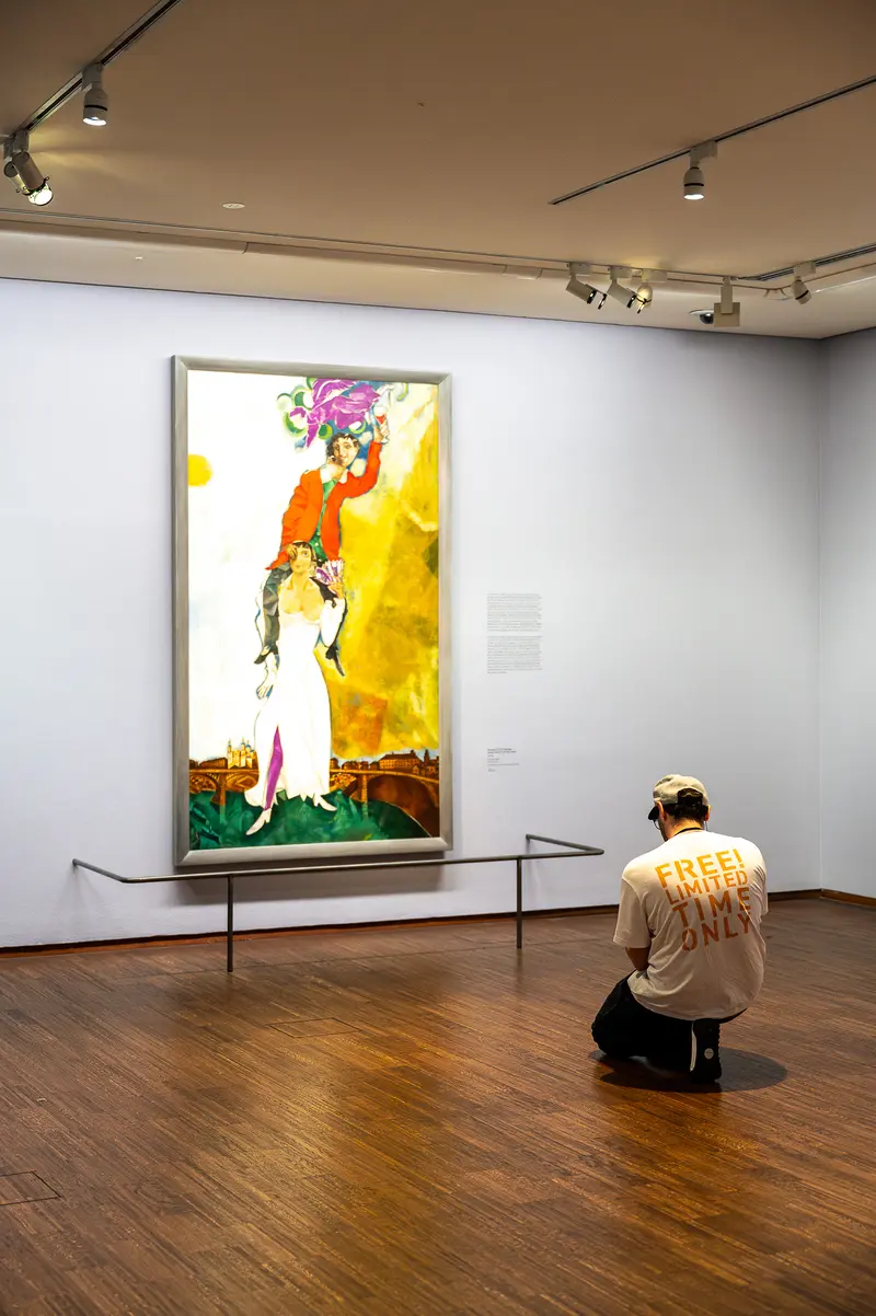 Solitary Viewer Contemplates Vibrant Artwork in Gallery Exhibition