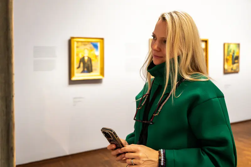 Visitor Examining Smartphone During Chagall Exhibition at Albertina Museum, Vienna