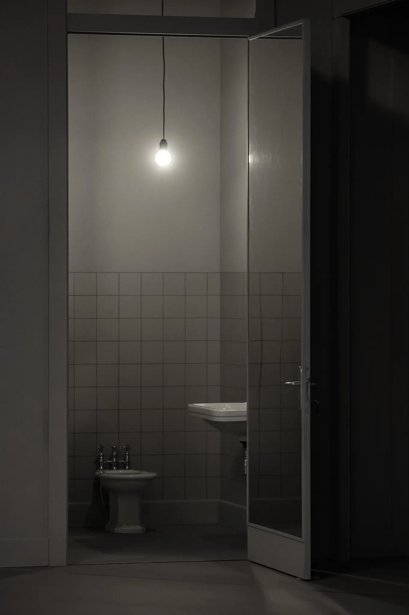 Minimalist Bathroom Interior with Suspended Light Bulb in Monochrome Setting