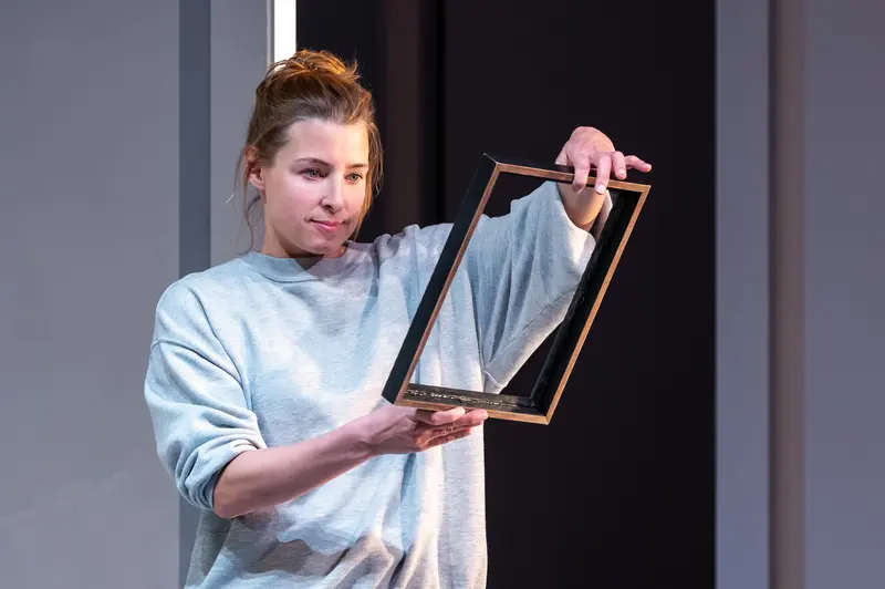 Performer Holding Framed Object During "Nachtlacht" Theater Production