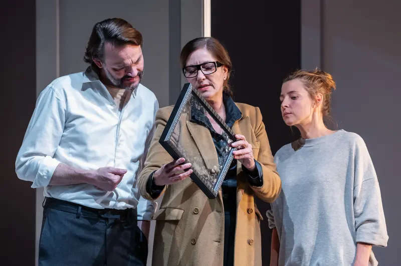 Actors Examining Framed Object During "Nachtlacht" Theater Performance