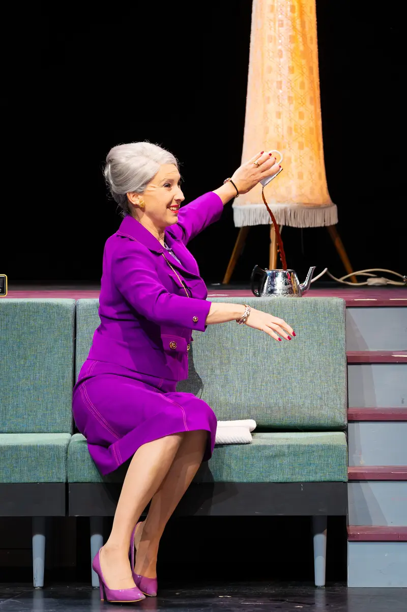Maria Scrooge on Stage at Theater Kammerspielen in Vibrant Purple Suit