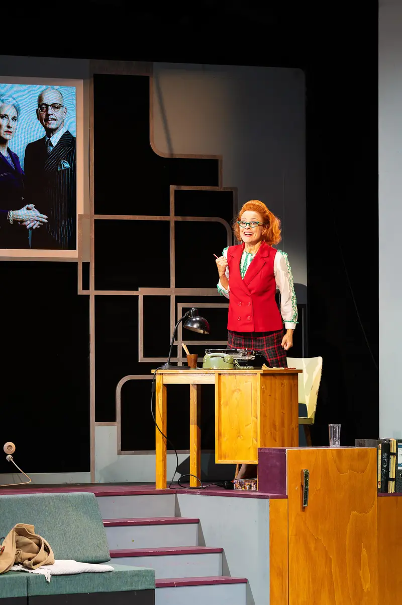 Red-Vested Actress Performing on Multilevel Stage Set for "Miss Scrooge"