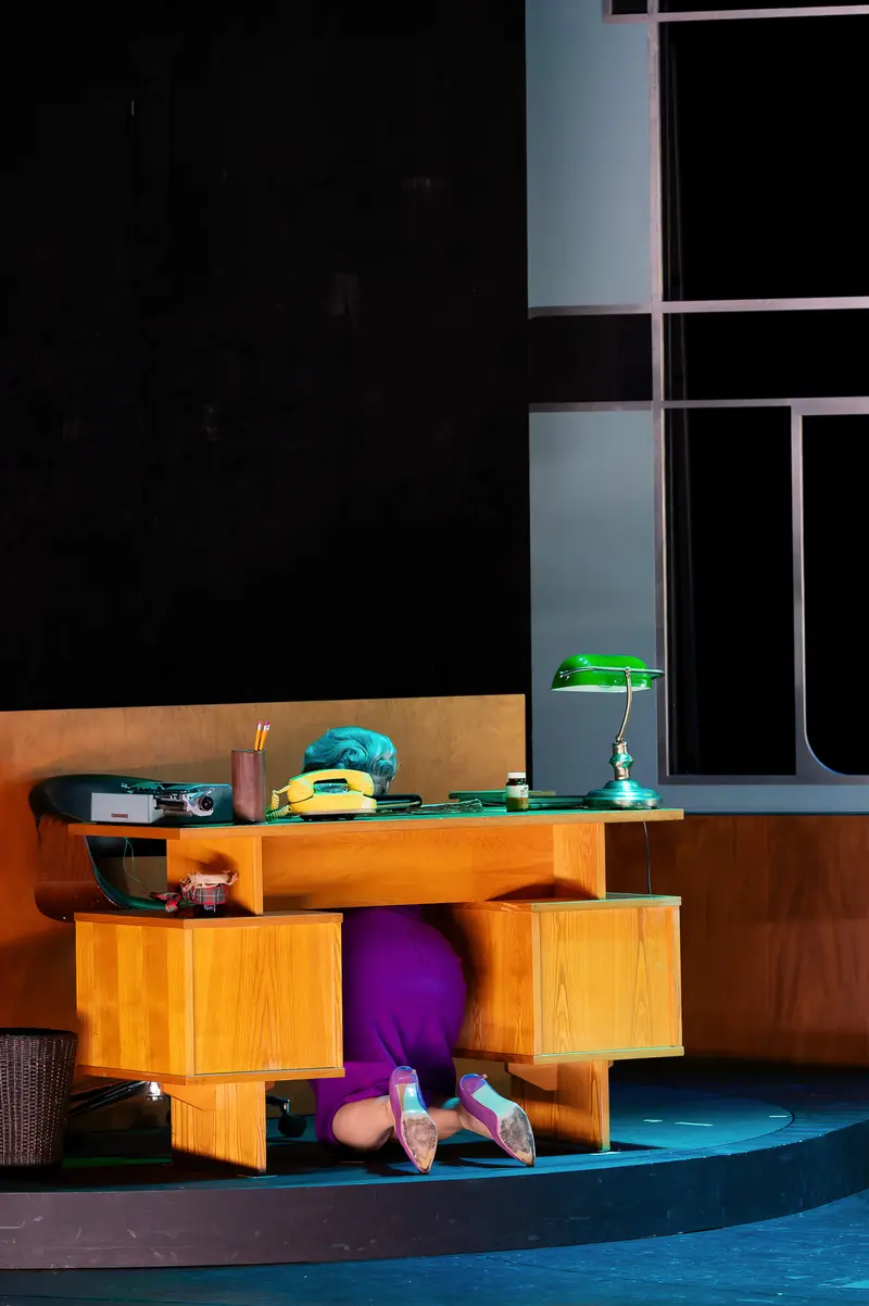 Actor Hidden Under Desk During "Miss Scrooge" Theater Performance