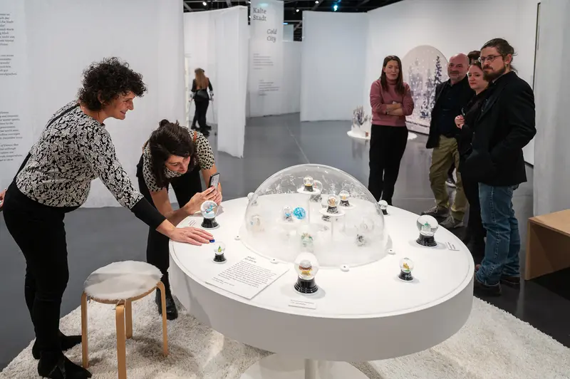 Winter in Vienna Exhibition: Visitors Examining Snowglobe Art Installation