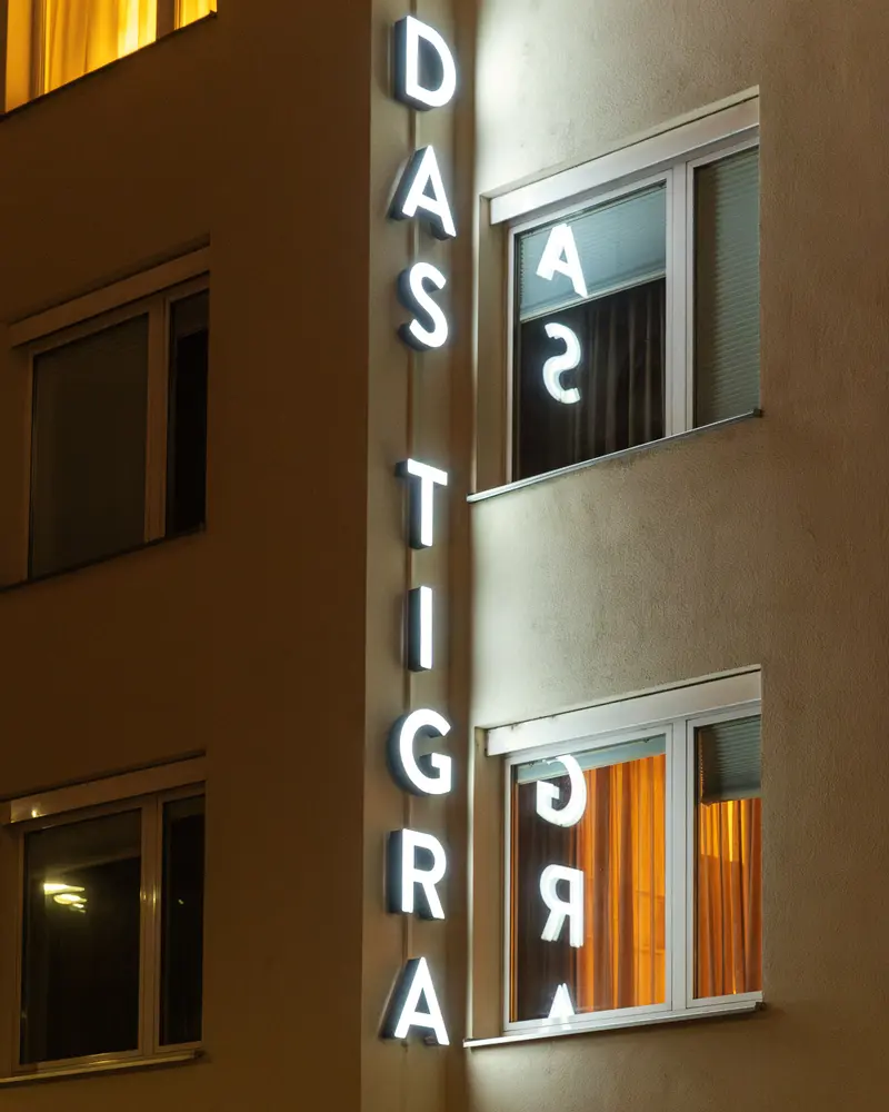 Das Tigra Hotel Exterior at Night Showing Illuminated Vertical Signage