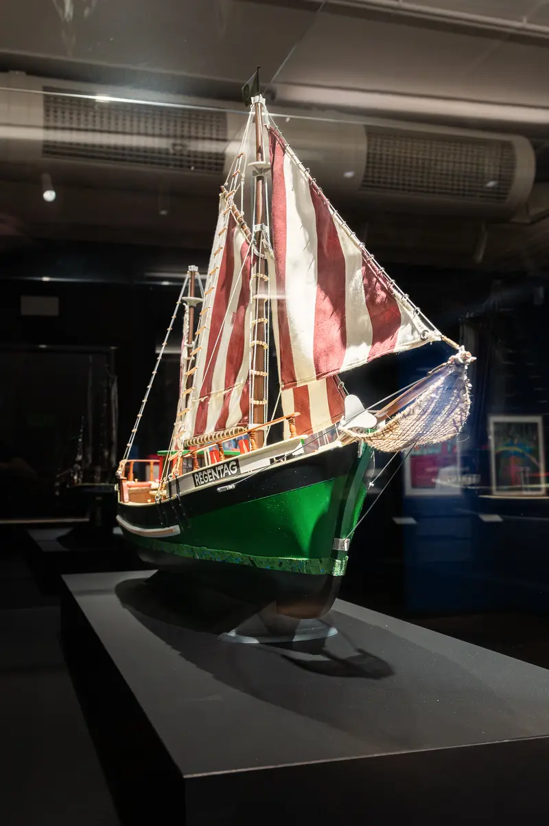Vintage Green and Red Sailboat Model Displayed in Museum Exhibition