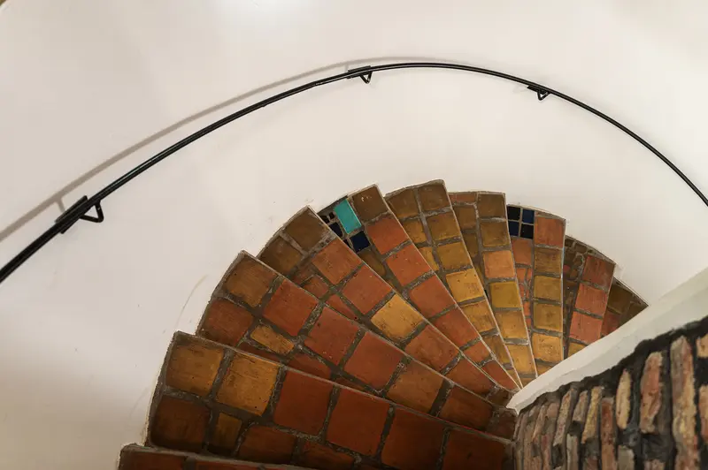 Spiraling Brick Staircase with Curved Handrail in Architectural Interior