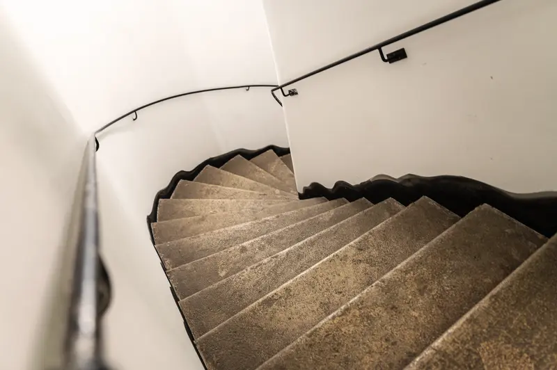 Spiral Staircase in Minimalist White Interior with Textured Steps