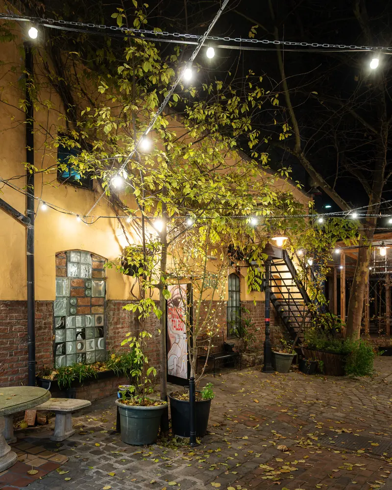 Nighttime Courtyard Illumination with String Lights and Urban Architectural Elements