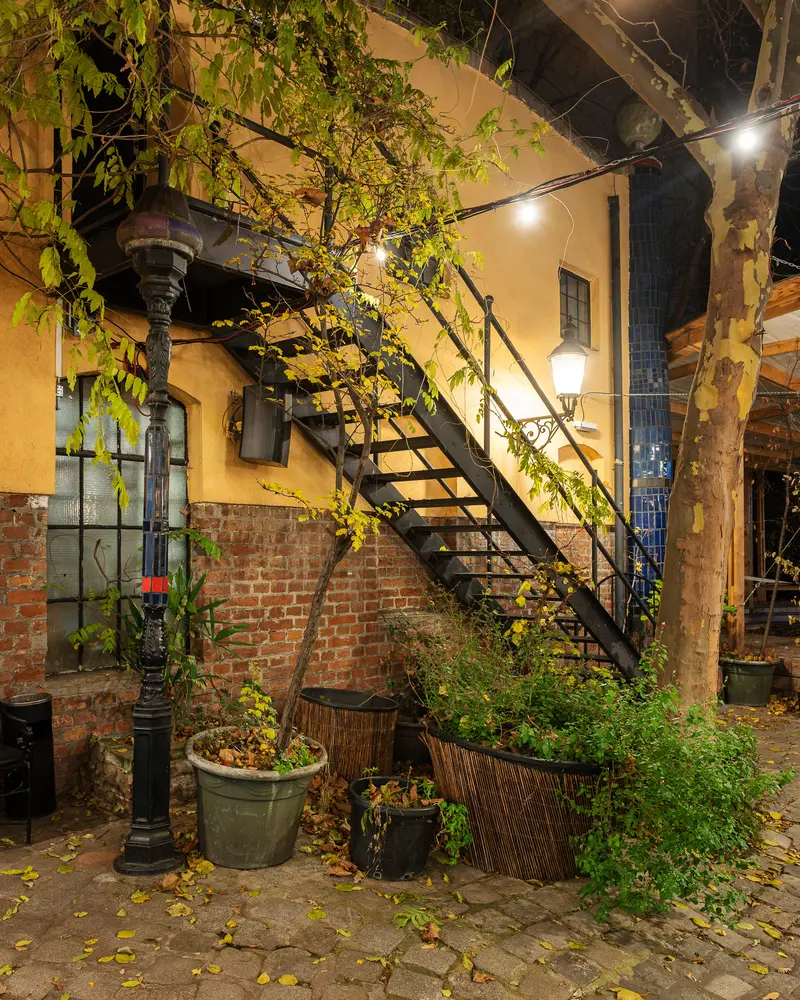 Moonlit Cobblestone Alley with Metal Staircase and Vintage Architecture