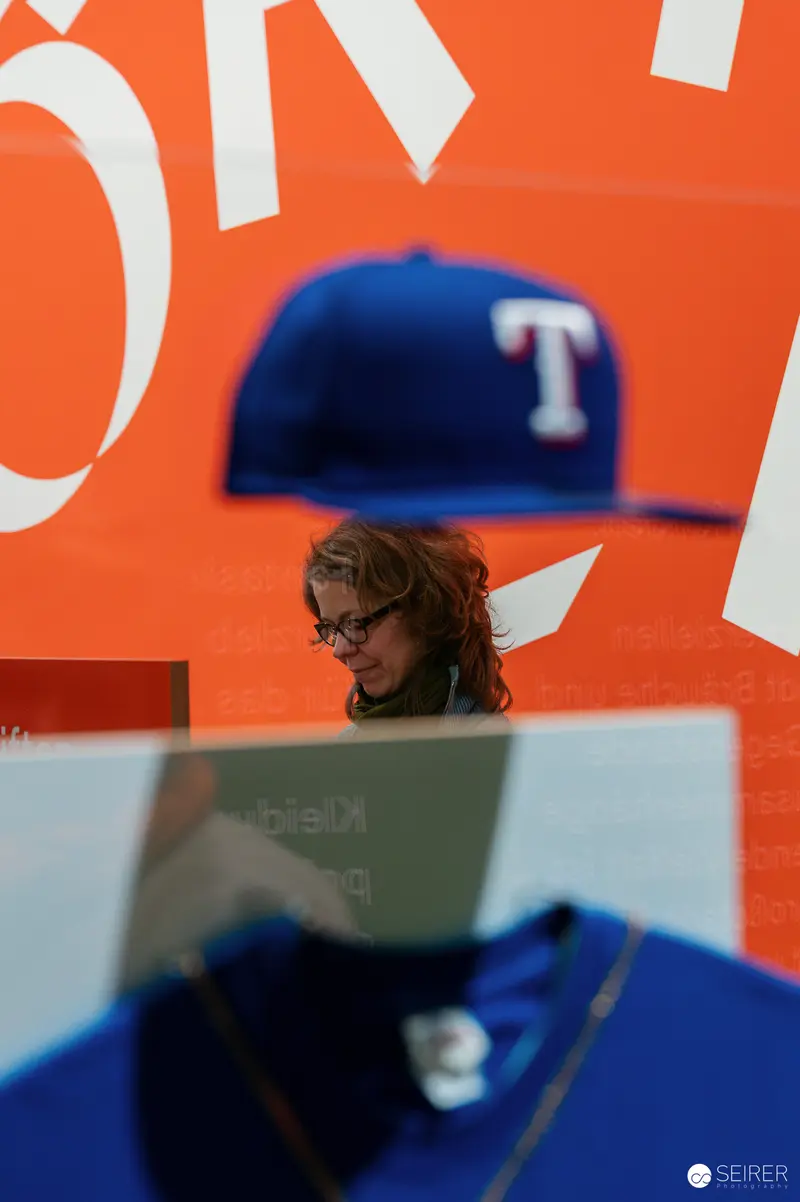Wien Museum 'MIXED' Ausstellungseröffnung. Layered View Through Suspended Texas Rangers Cap During Liz Metta Performance