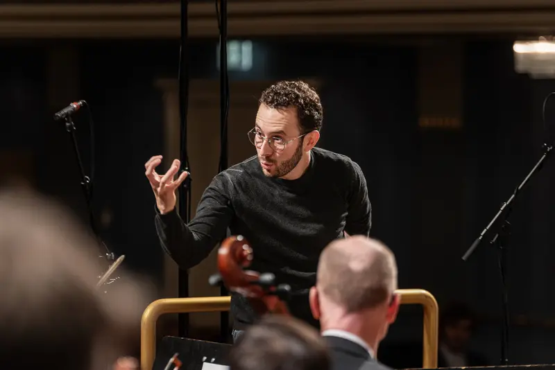 TU Orchestra Conductor Gesturing During 40th Anniversary Concert at Konzerthaus Wien