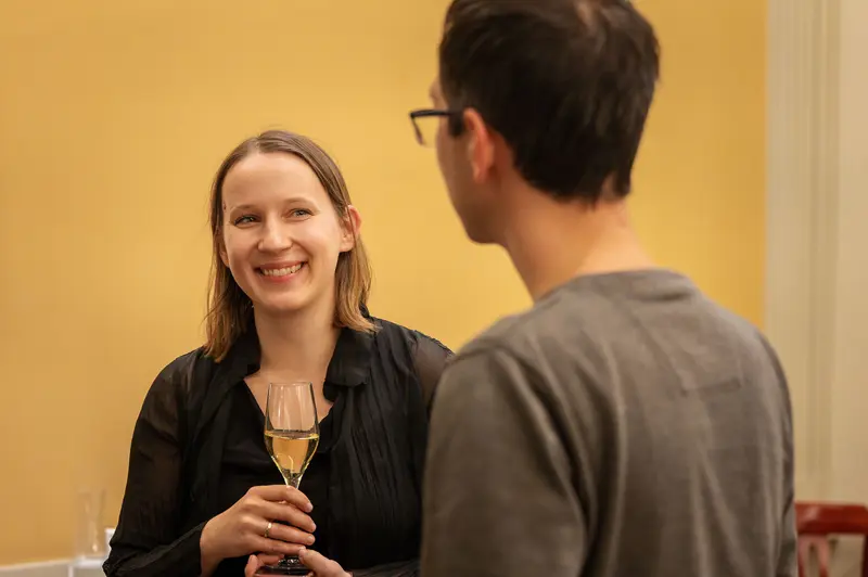 Two People Conversing at Social Event with Wine Glass