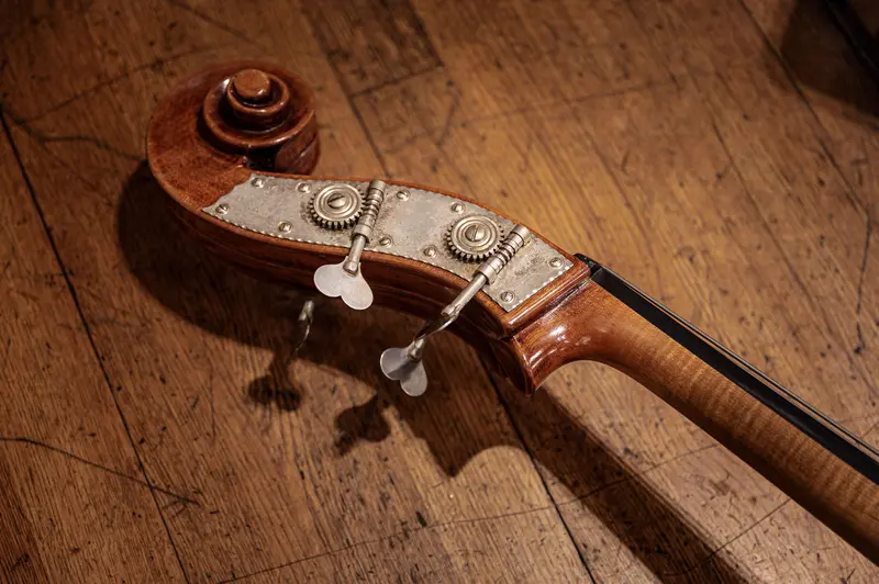 Vintage Violin Scroll and Tuning Mechanism on Wooden Floor