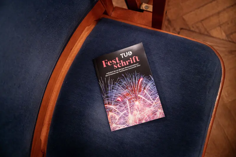 Festival Schrift Book Displayed on Blue Chair with Wooden Frame