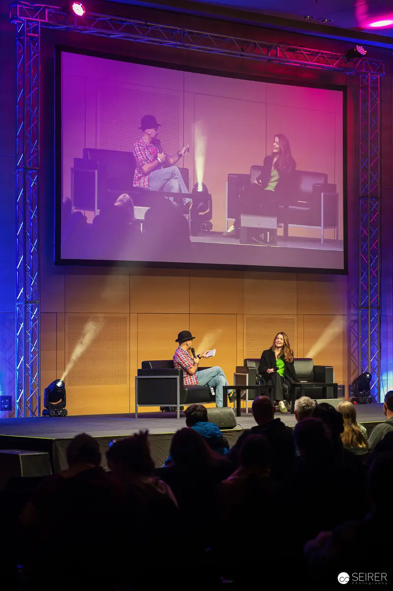 Vienna ComicCon 2024: Panel Discussion on Stage with Large Screen Backdrop