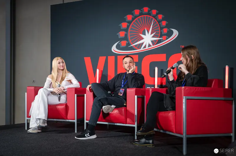 Vienna ComicCon 2024 Panel Discussion with Three Speakers on Red Chairs