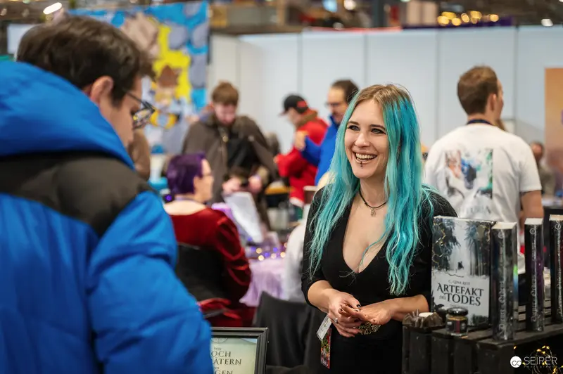 Smiling Booth Attendant at Vienna ComicCon 2024 with Turquoise Hair