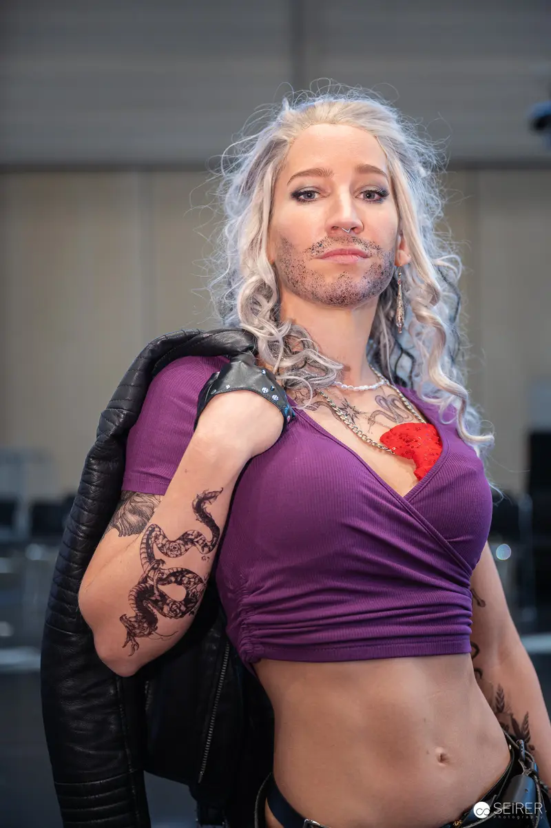 Cosplayer in Purple Top with Intricate Tattoos at Vienna ComicCon 2024