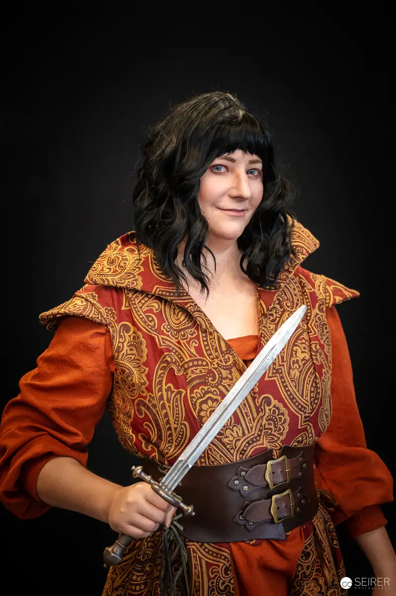 Medieval Cosplayer in Ornate Red Jacket Wielding Sword at Vienna ComicCon 2024