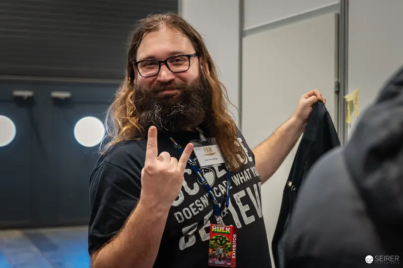 Comic Con Attendee Celebrates Geek Culture with Rock Gesture and Graphic Tee
