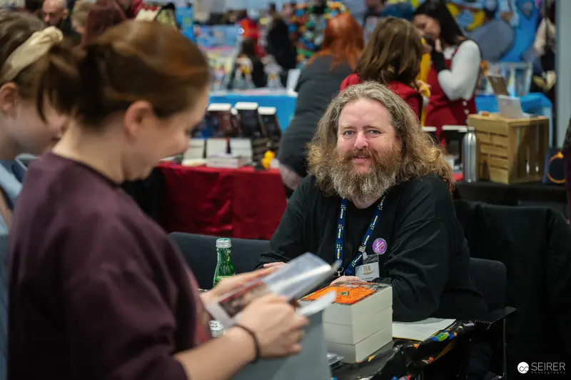 Bearded Comic Con Attendee Smiling at VIECC 2024 Vendor Table