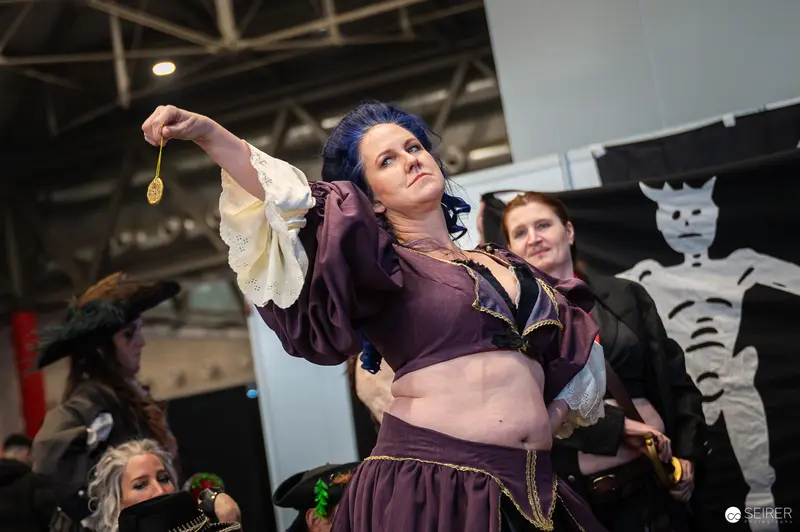 Purple-Clad Cosplayer Performing Dynamic Pose at Vienna ComicCon 2024