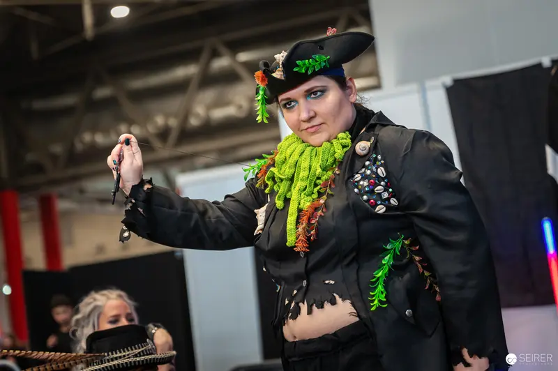 Cosplayer in Elaborate Green and Black Costume at Vienna ComicCon 2024