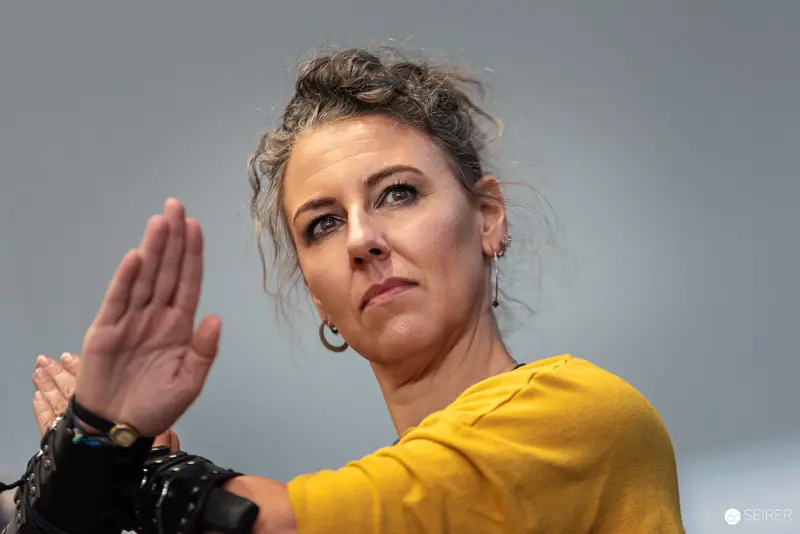 Vienna ComicCon 2024: Cosplayer in Yellow Gestures Dramatically