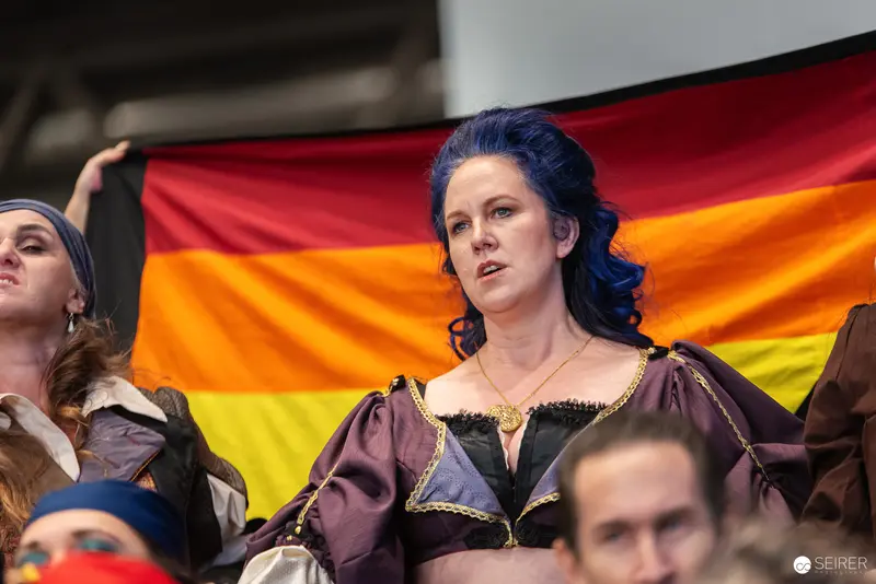 Woman in Period Costume at Vienna Event with LGBTQ+ Pride Flag