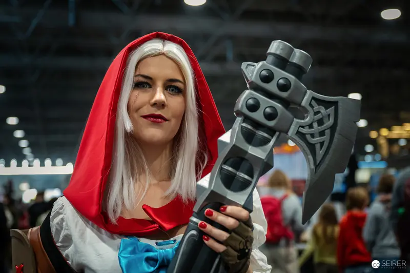 Cosplayer in Red Hood Wielding Fantasy Axe at Vienna ComicCon 2024