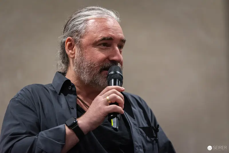 Speaker Addressing Audience at Vienna ComicCon 2024 with Microphone
