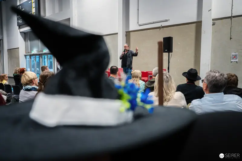 Speaker Presents at Event with Graduates in Audience Foreground