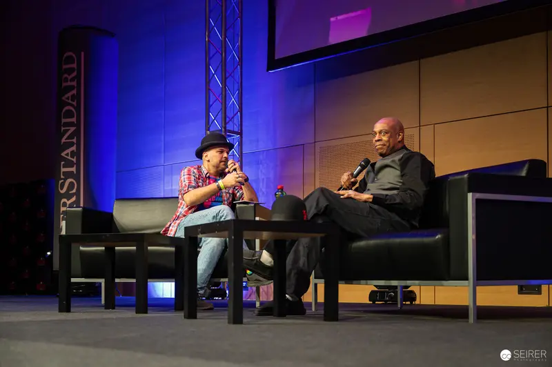 Fireside Chat at Tech Conference with Two Speakers on Stage