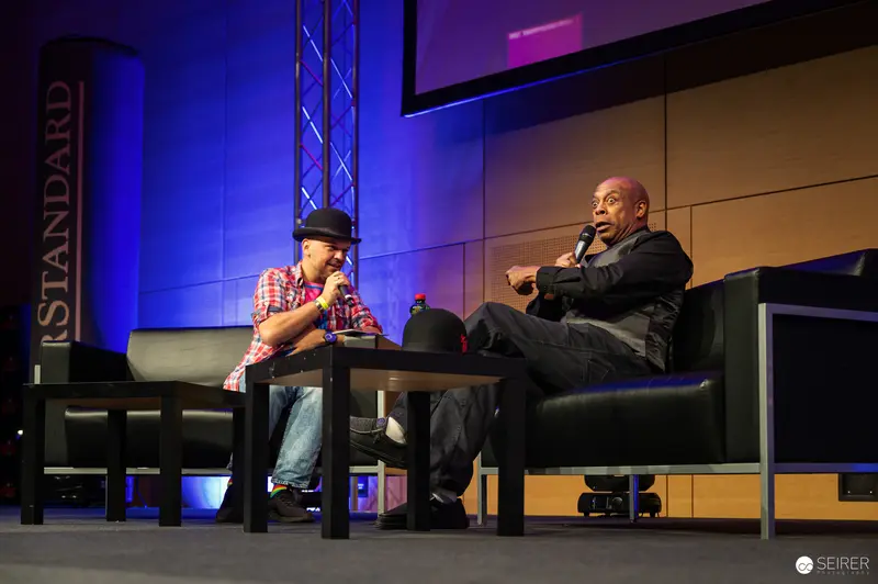 Two Speakers at Event Discussing Creative Topics on Stage