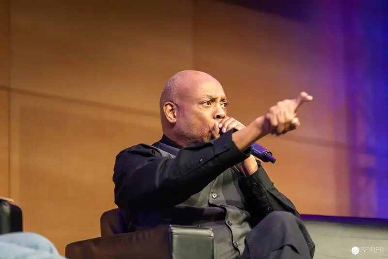 Passionate Speaker Gesturing Emphatically at Conference Microphone