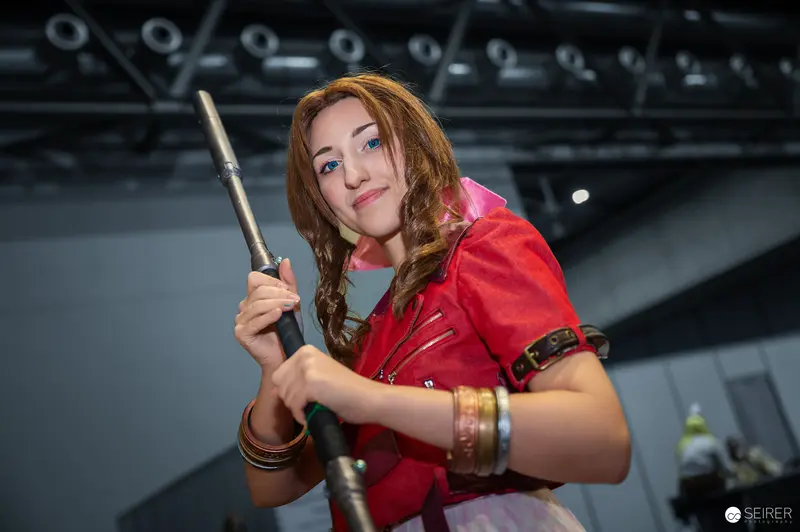 Cosplayer in Red Costume Wielding Prop Staff at Vienna ComicCon 2024