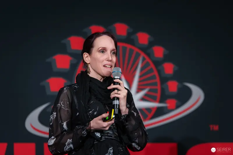 Speaker on Stage at Vienna ComicCon 2024 in Black Sheer Blouse