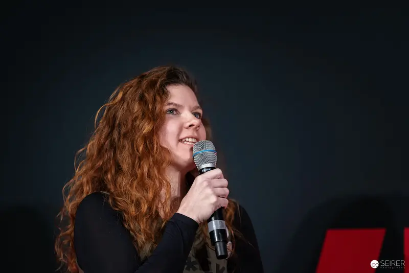 Curly-Haired Performer with Microphone at Vienna ComicCon 2024