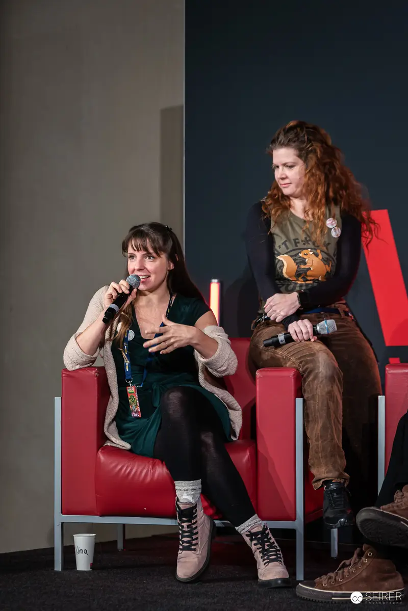 Two Cosplayers at Vienna ComicCon 2024 on Red Chairs