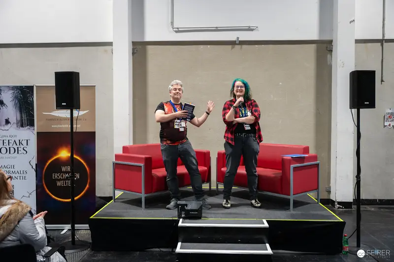 Two Presenters at Vienna ComicCon 2024 on Red Chairs Stage